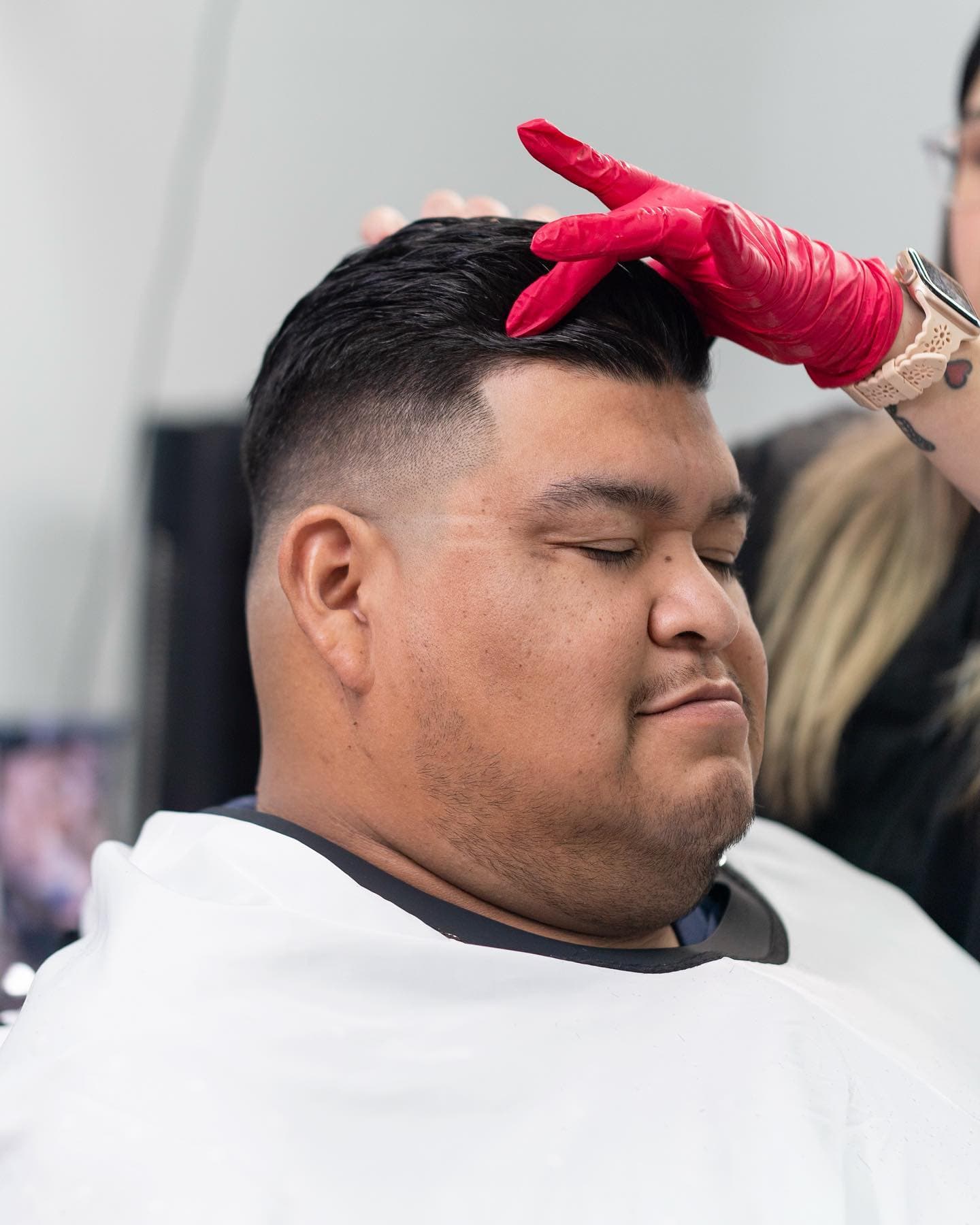 Barber Addy styling a fresh cut in progress, precision work up close