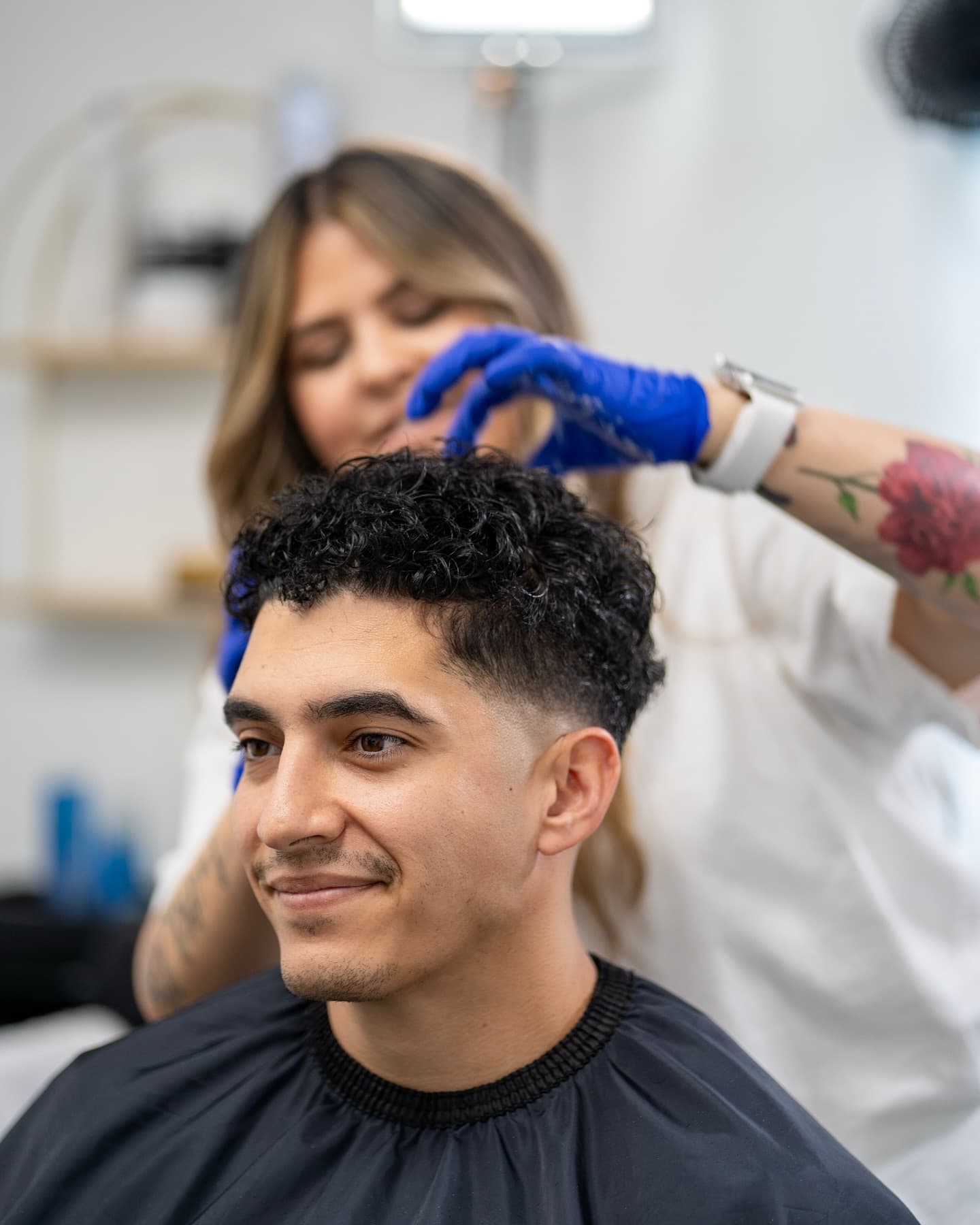 Barber Addy styling a fresh haircut for a client in her studio